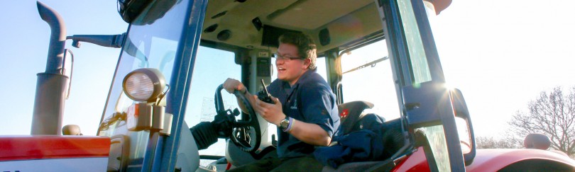 Farmer in a tractor using a radio to communicate